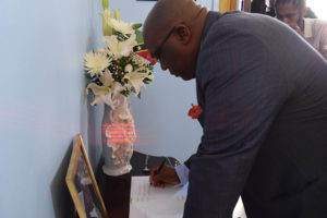 Prime Minister Harris signing Book of Condolences at Government House